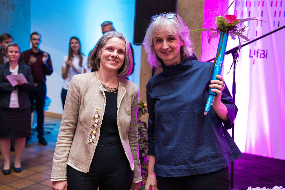 Foto: Prof. Dr. Sabine Weinert (links) übergab Prof. Dr. Cordula Artelt symbolisch einen blumengeschmückten Staffelstab.